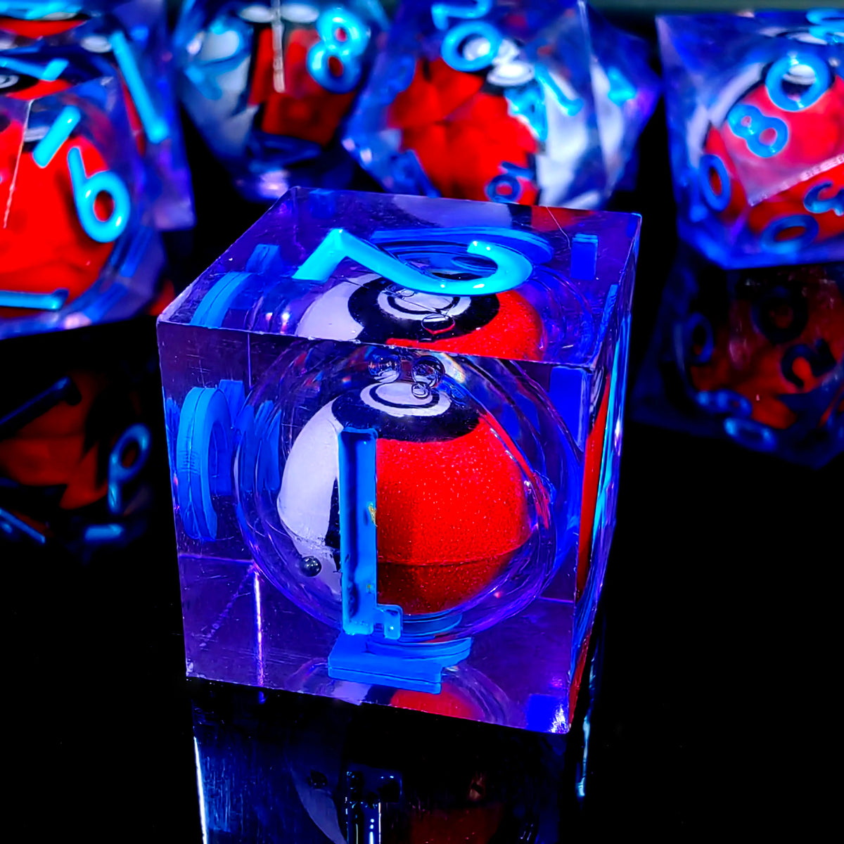 Gros plan d'un jeu de dés polyédriques de différentes couleurs, y compris bleu et rouge, posés sur une surface réfléchissante