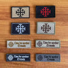 A collection of embroidered tactical patches featuring a cross design in red, black, and gray tones.