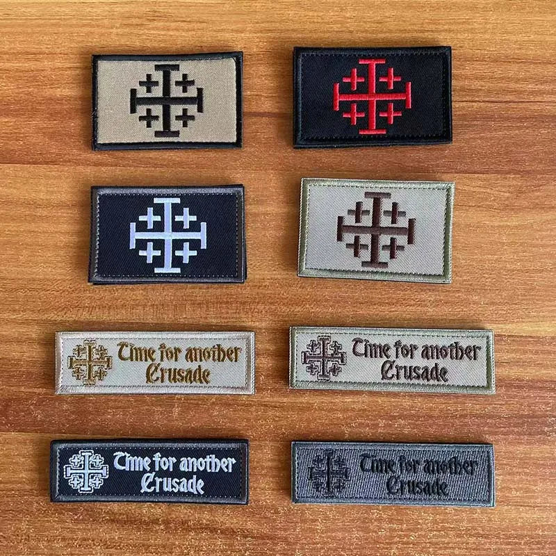 A collection of embroidered tactical patches featuring a cross design in red, black, and gray tones.