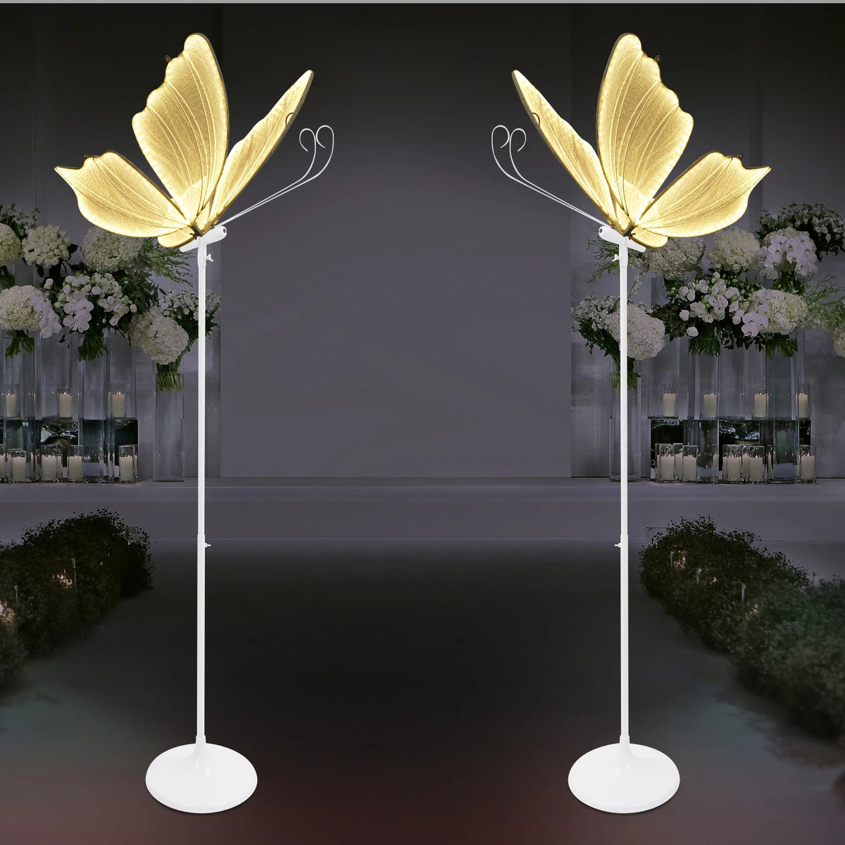 Ein Set romantischer Schmetterlings-Bodenlampen mit goldfarbenen Flügeln vor dunklem Hintergrund.