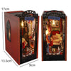A wooden book nook kit featuring a dark gate design with internal lighting and miniature furniture.