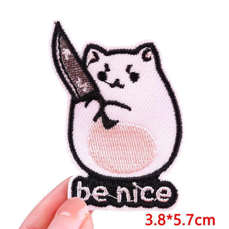 A pink cartoon cat with a sword is embroidered on a black patch.