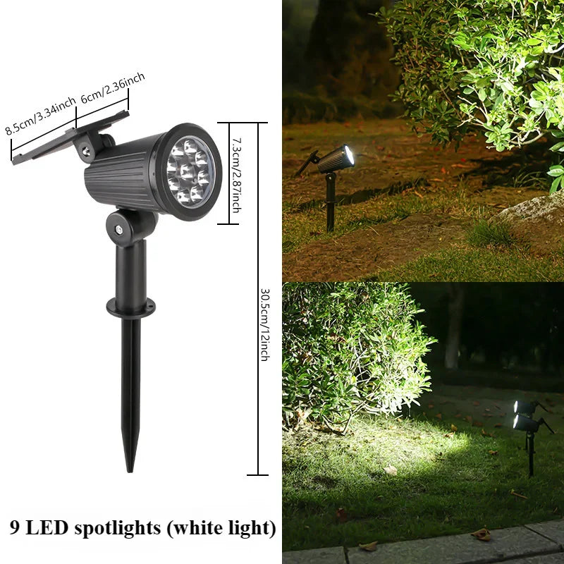 A black LED spotlight with nine white light bulbs mounted on a stand, shown in an outdoor garden setting.