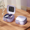 A light purple compact magnetic sewing kit with an open lid displaying various needles and thread colors on a wooden surface.