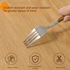 A silver fork is shown on a wooden surface with icons indicating it is scratch-resistant, easy to clean, environmentally frie
