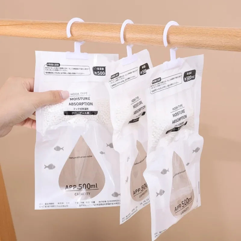 White moisture absorber bags with hook ties hanging on a wooden rod
