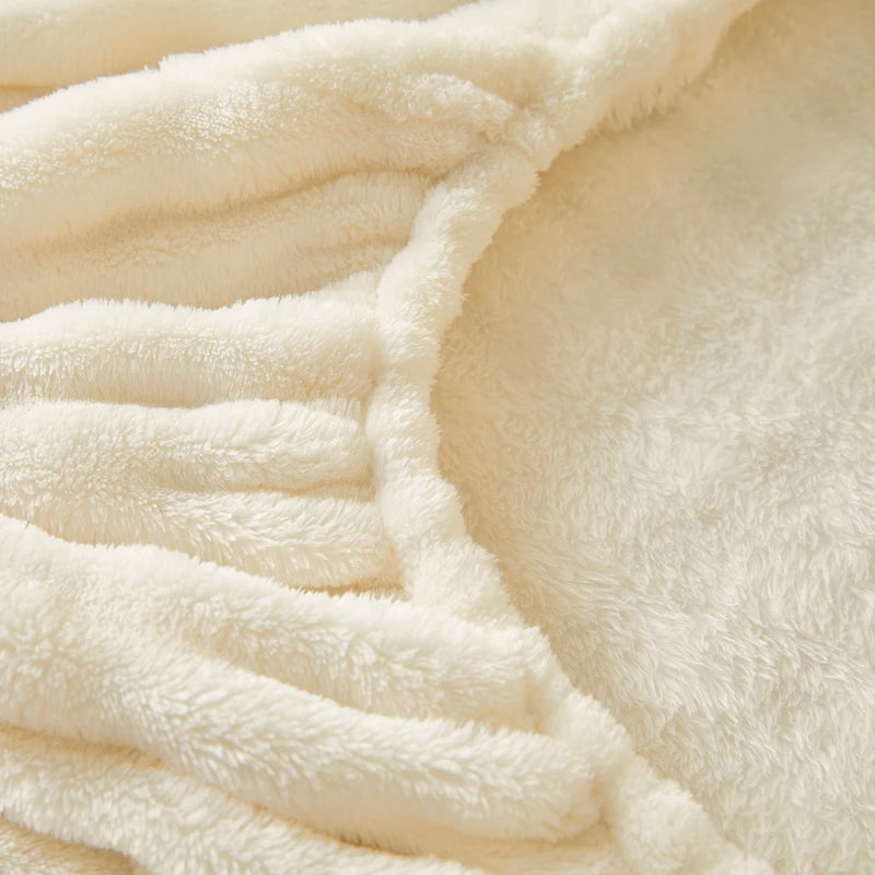 Close-up of a cream-colored cozy faux fur fitted sheet showing its texture and folds.