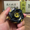 A hand holds a black and gold precision metal fidget spinner, showing its detailed design.