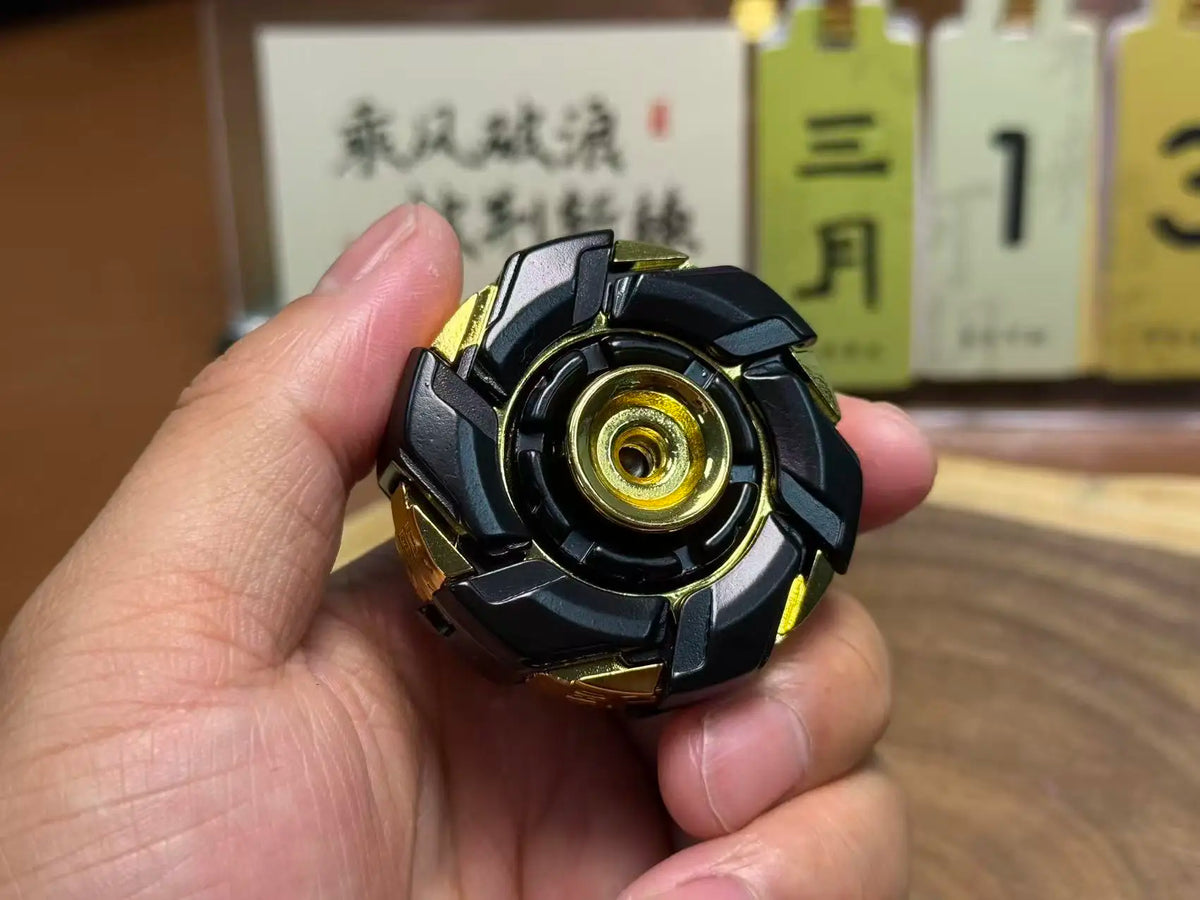 A hand holds a black and gold precision metal fidget spinner, showing its detailed design.