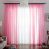 Pink sheer voile curtains with a white pompom hanging in a bright window