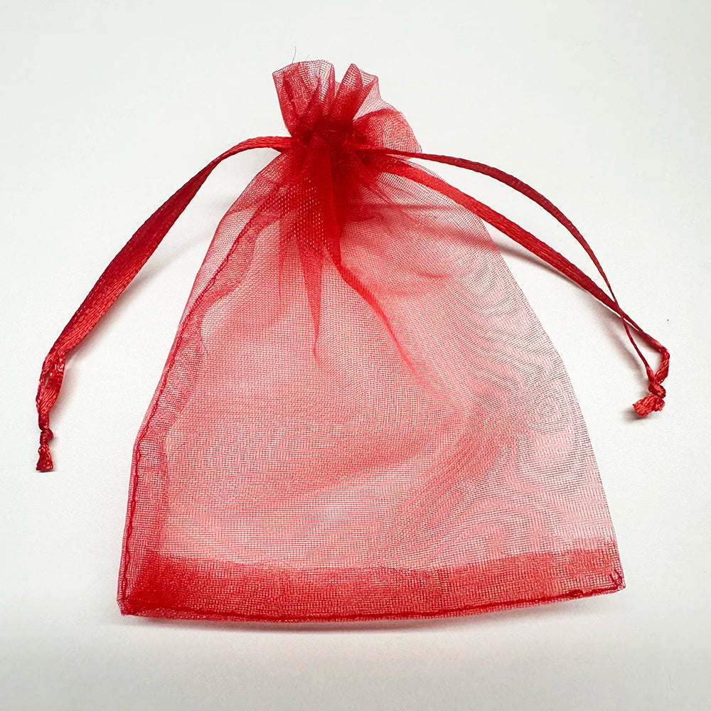 A clear red organza drawstring bag tied with a ribbon, suitable for gifts or party favors.