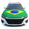 A white car hood covered with a green and yellow Brazilian flag design featuring the motto Ordem e Progresso.