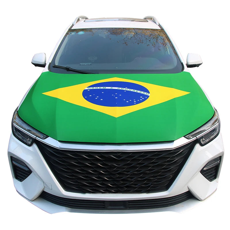 A white car hood covered with a green and yellow Brazilian flag design featuring the motto Ordem e Progresso.
