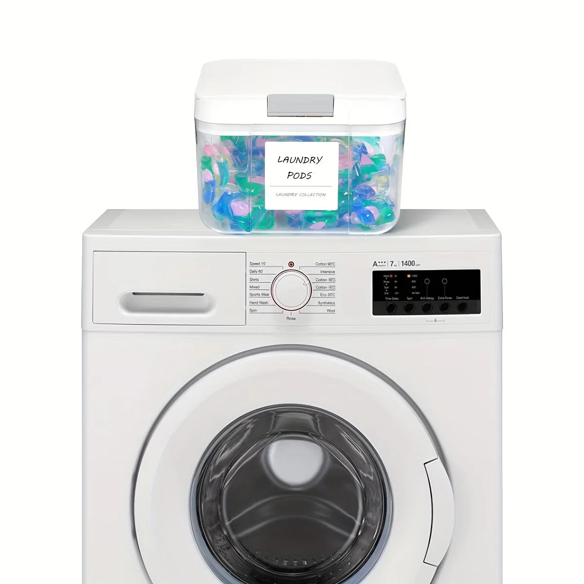 A white automatic pop-up laundry pod holder with a clear container of colorful laundry pods sits on top of a white washing ma