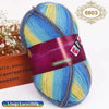A ball of gradient dyed wool blend yarn in blue, yellow, and green colors with a purple label.