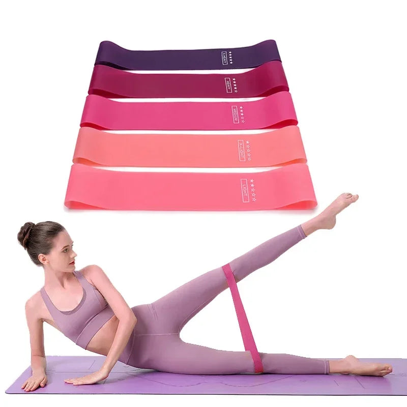 A set of stacked pink and purple resistance bands is shown next to a woman performing a yoga pose on a purple mat.