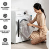 A woman is folding a gray blanket inside a white washing machine, demonstrating its anti-tearing and cozy features.