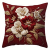 A decorative pillow featuring red and cream floral embroidery on a dark red fabric.