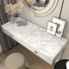 A white marble vanity table with a gold frame and a mirror, decorated with dried pampas grass.