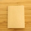 A blank A6 Kraft paper notebook lying on a wooden surface.