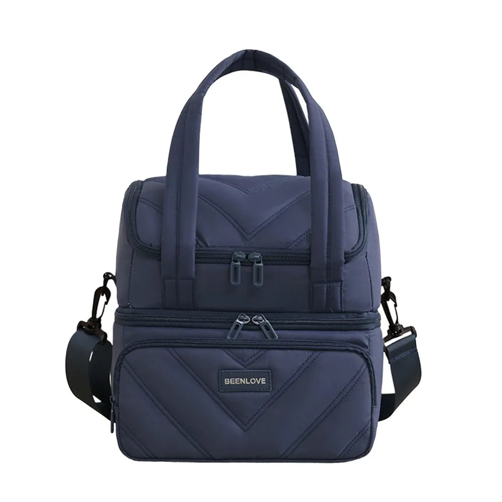 A navy blue insulated leakproof reusable lunch bag with a quilted pattern and carrying straps.