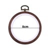 A round wooden embroidery hoop with a metal handle, used for cross-stitch and needlework.