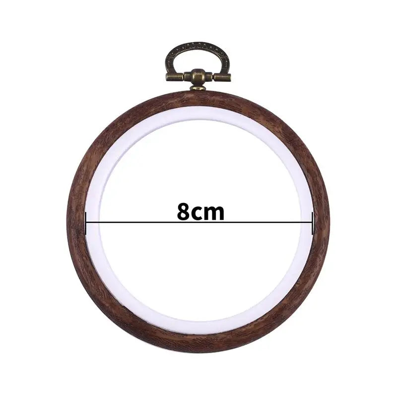 A round wooden embroidery hoop with a metal handle, used for cross-stitch and needlework.