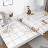 Roll of self-adhesive marble contact paper for kitchen and bathroom surfaces displayed on a white table.