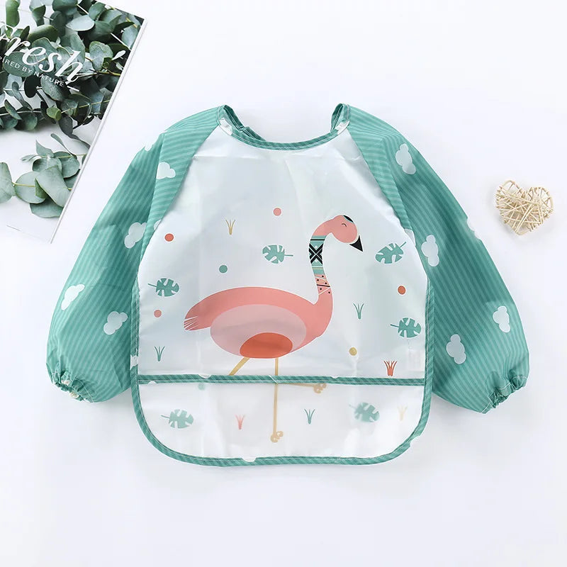 A pink flamingo patterned waterproof long-sleeve baby feeding smock with a green trim.