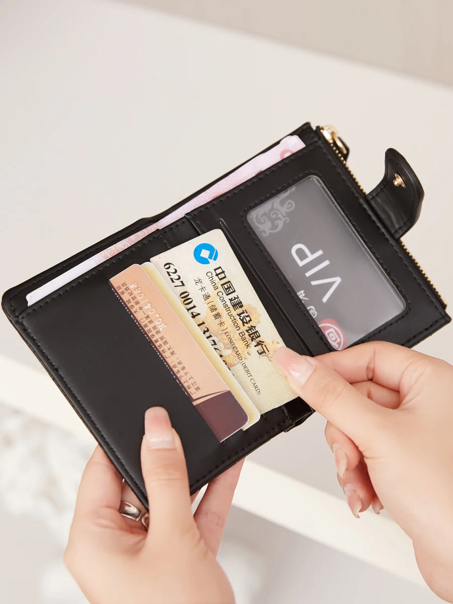 A hand is opening a black crocodile-embossed PU leather bifold wallet to display several credit cards.