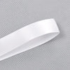 A roll of white double face satin ribbon against a gray textured background.