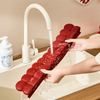 Hände spülen einen roten Silikonsink-Schutzabfluss unter fließendem Wasser in einer Badewanne.