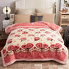A pink weighted plush raschel blanket with floral embroidery displayed on a bed.