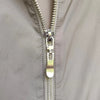 Close-up of a silver metal zipper pull replacement slider on a gray fabric garment.