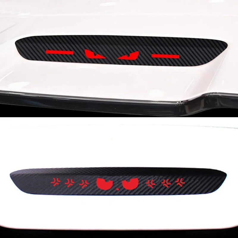 Black carbon fiber brake light sticker with red markings applied to a white car surface.