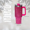 A pink rhinestone tumbler with a straw and handle, featuring stainless steel construction and vacuum insulation.