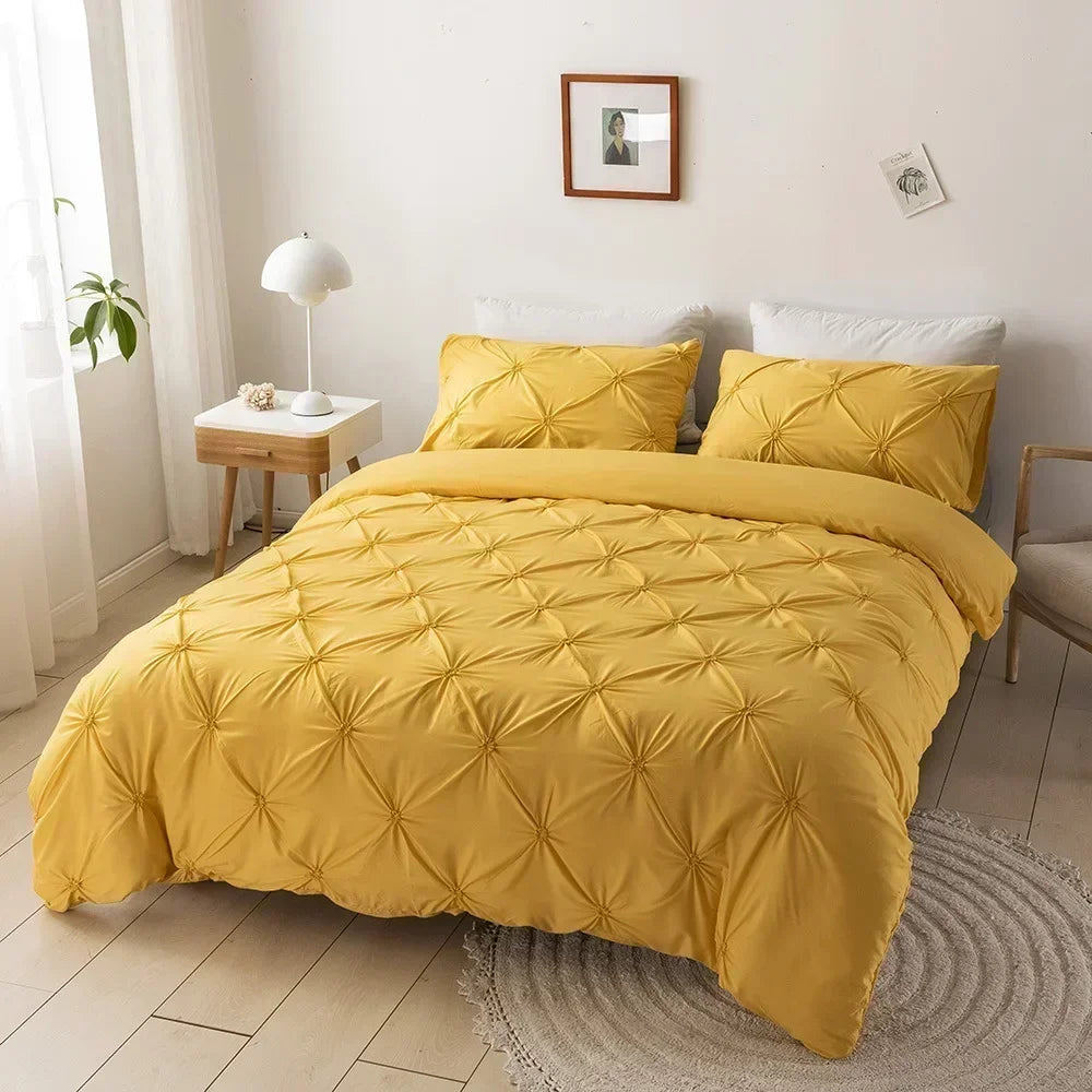 A yellow 3D pinch pleated duvet cover set displayed on a bed with white linens and natural light.