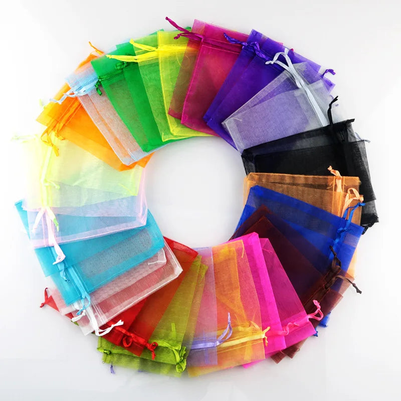 A circular arrangement of colorful organza drawstring jewelry gift bags in various shades of green, yellow, pink, purple, and