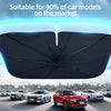 A black foldable car windshield sun shade umbrella is shown above several cars on a road.