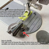 A close-up of a hemming foot attachment being installed on a sewing machine needle plate.