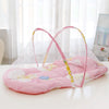A pink portable crib mosquito net with a pillow and cotton pad is displayed on a white surface.