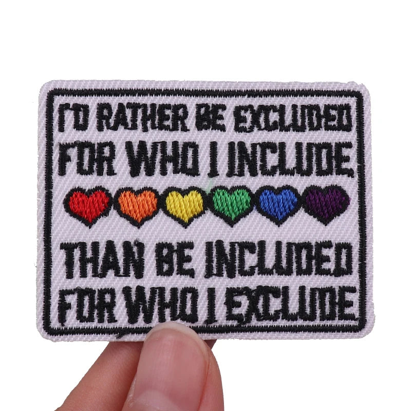 A set of embroidered iron-on patches featuring text and colored hearts on a white fabric background.