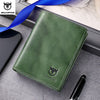 A dark green genuine leather men's bifold wallet with stitching is shown next to a pen and a blue ribbon.
