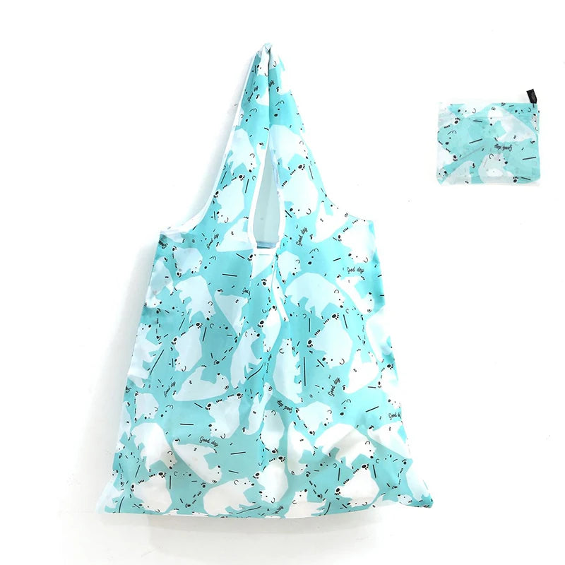 A light blue and white patterned reusable shopping tote bag with an attached carry pouch.