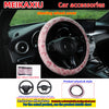 A pink leopard print plush steering wheel cover shown in a car interior setting.