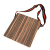 A compact travel cajon drum with a wooden body and adjustable black and orange strap.