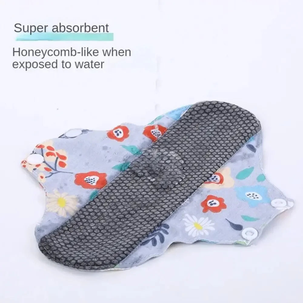 Reusable cotton menstrual pads with a floral pattern shown against a white background.