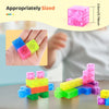 A set of transparent magnetic building blocks in various colors like pink, yellow, blue, and green stacked on a table.
