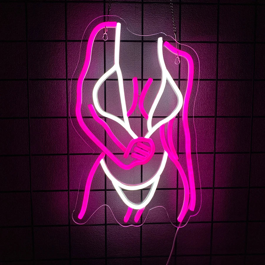 A neon sign shaped like a pair of embracing figures glowing bright pink on a dark grid background.