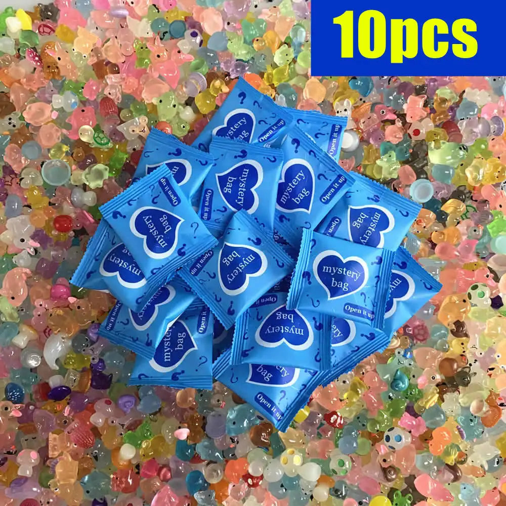 Eine Sammlung von 10 blauen Überraschungstüten mit Herzmotiven, verstreut auf einem Bett aus farbenfrohen, leuchtenden Plasti
